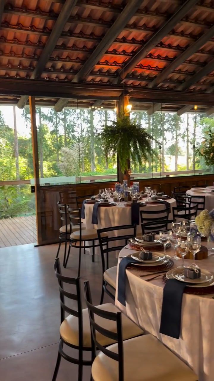 Mesas decoradas com vista para o bosque pelas janelas